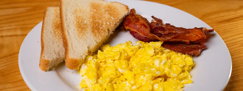 Breakfast platter with bacon, eggs, and toast.